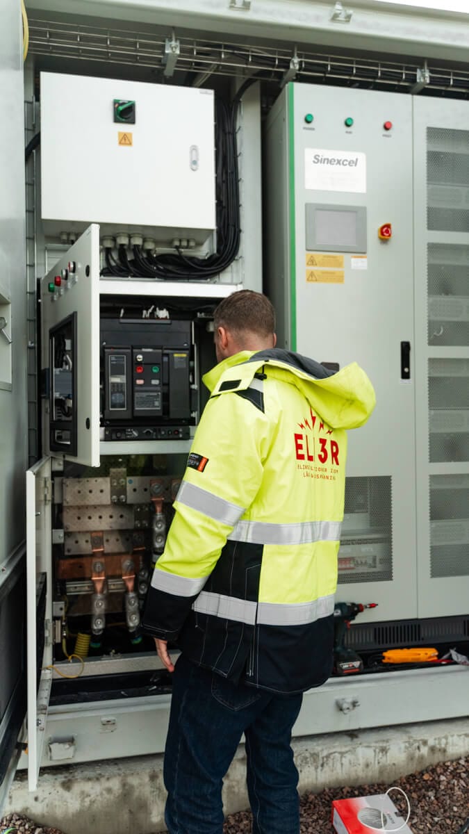 EL13R-tekniker vid ett öppet laddskåp under ett servicebesök